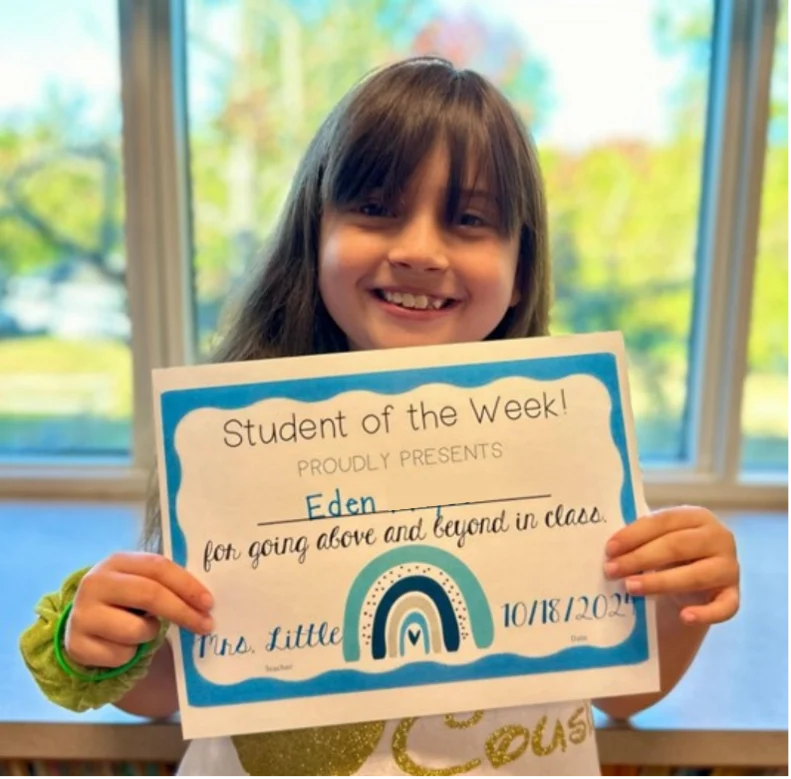 Young girl holding a school accomplishment award