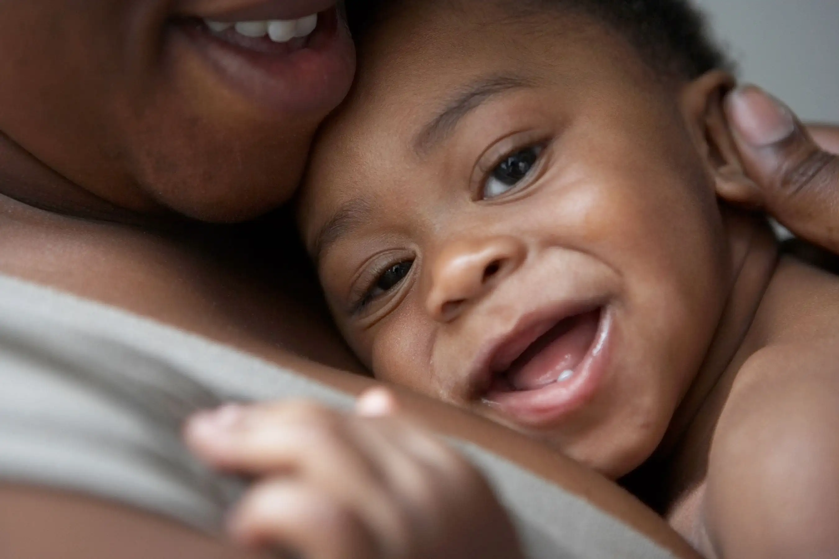 Smiling baby laying on mother's chest