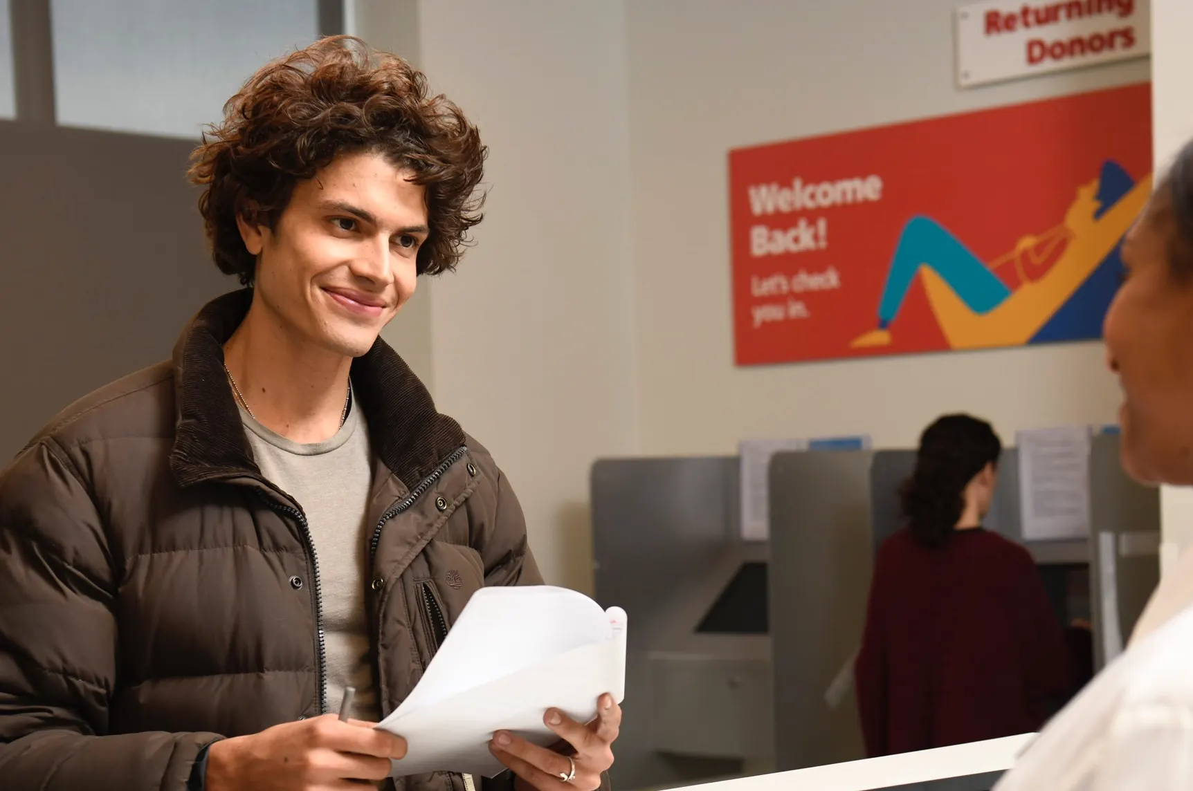 Young man walking in to a csl plasma center